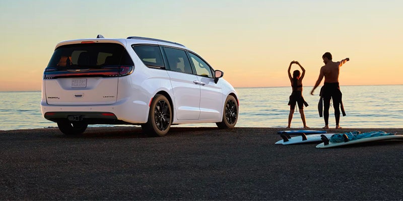 a white pacifica parked on the beach