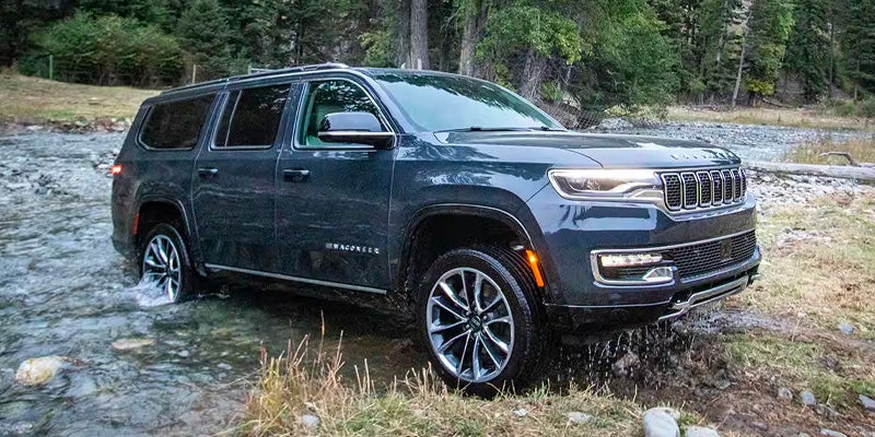A white 2026 Jeep Grand Wagoneer hauling a trailer.