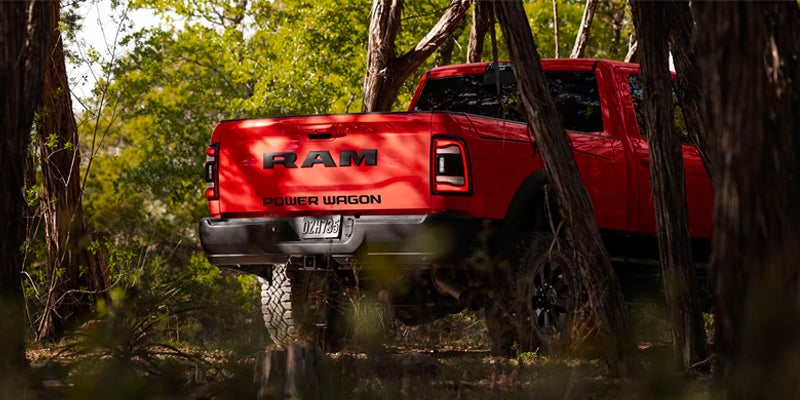 the back of a red ram 2500 between trees