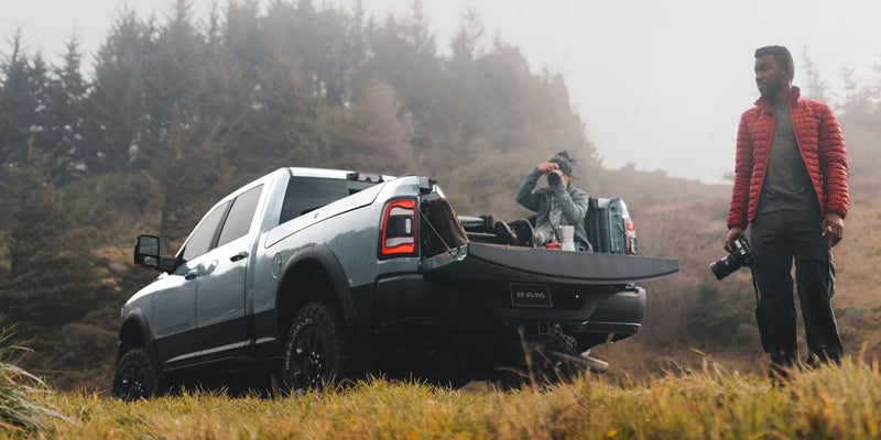 a ram 2500 parked in the middle of a field with the tailgate down