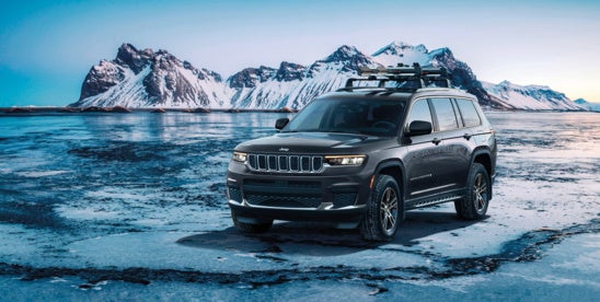 a jeep grand cherokee parked on ice in the mountains