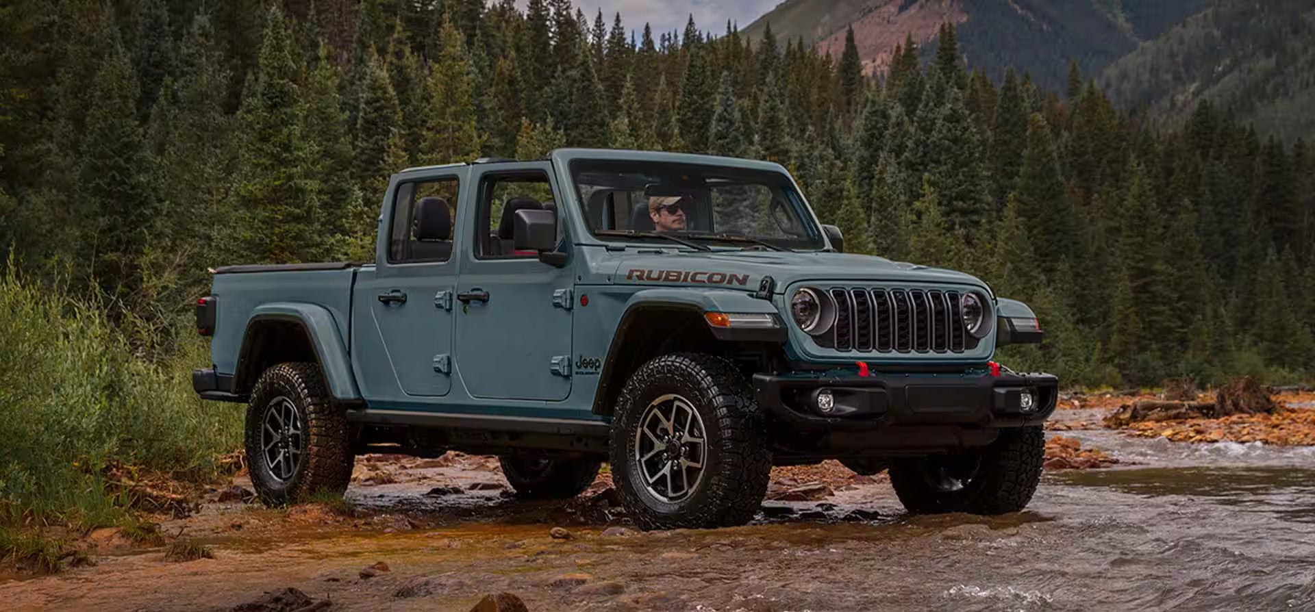 a blue jeep gladiator hauling a silver trailer in the snow