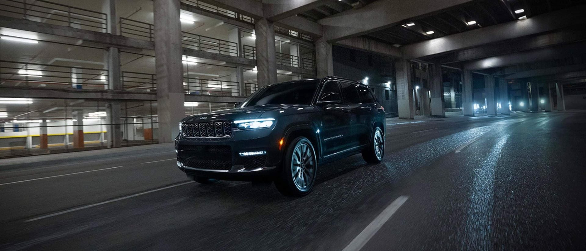 a jeep grand cherokee driving in the city at night