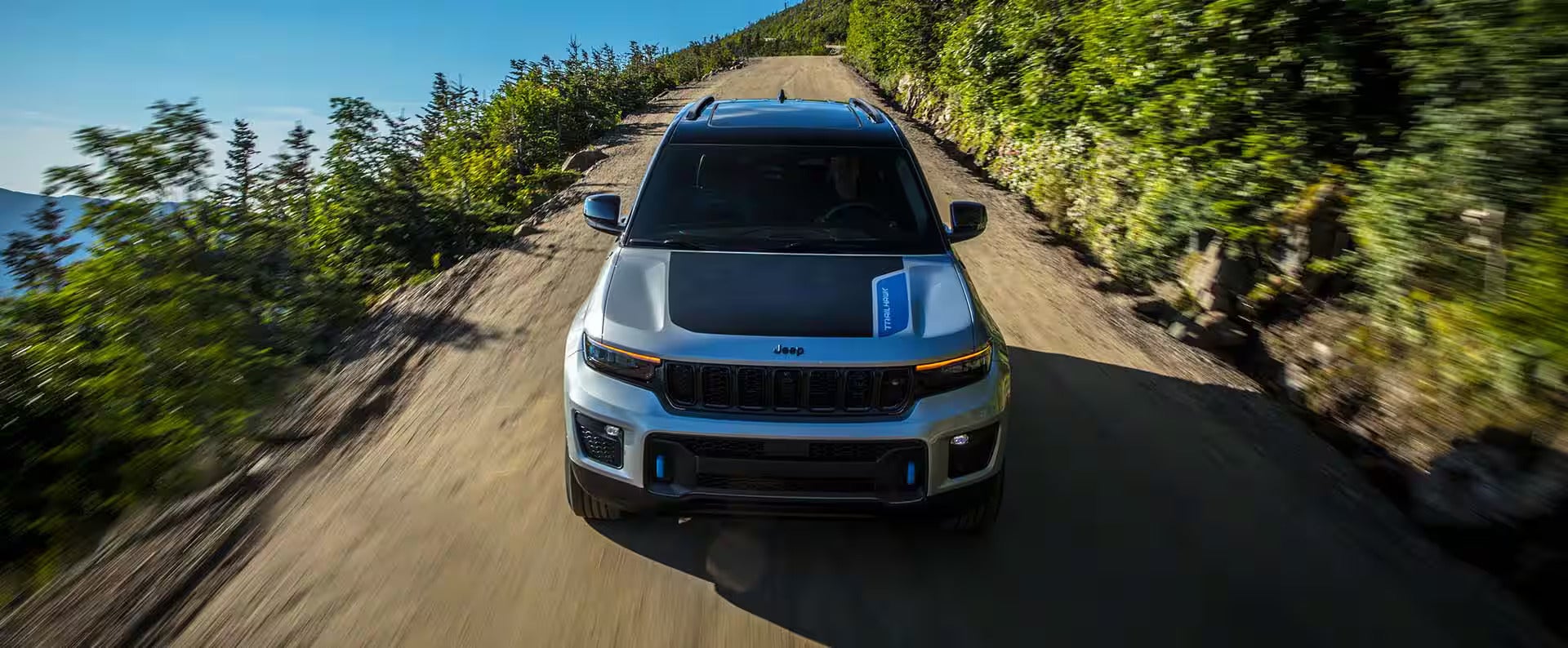the front of a jeep cherokee going driving down a dirt road