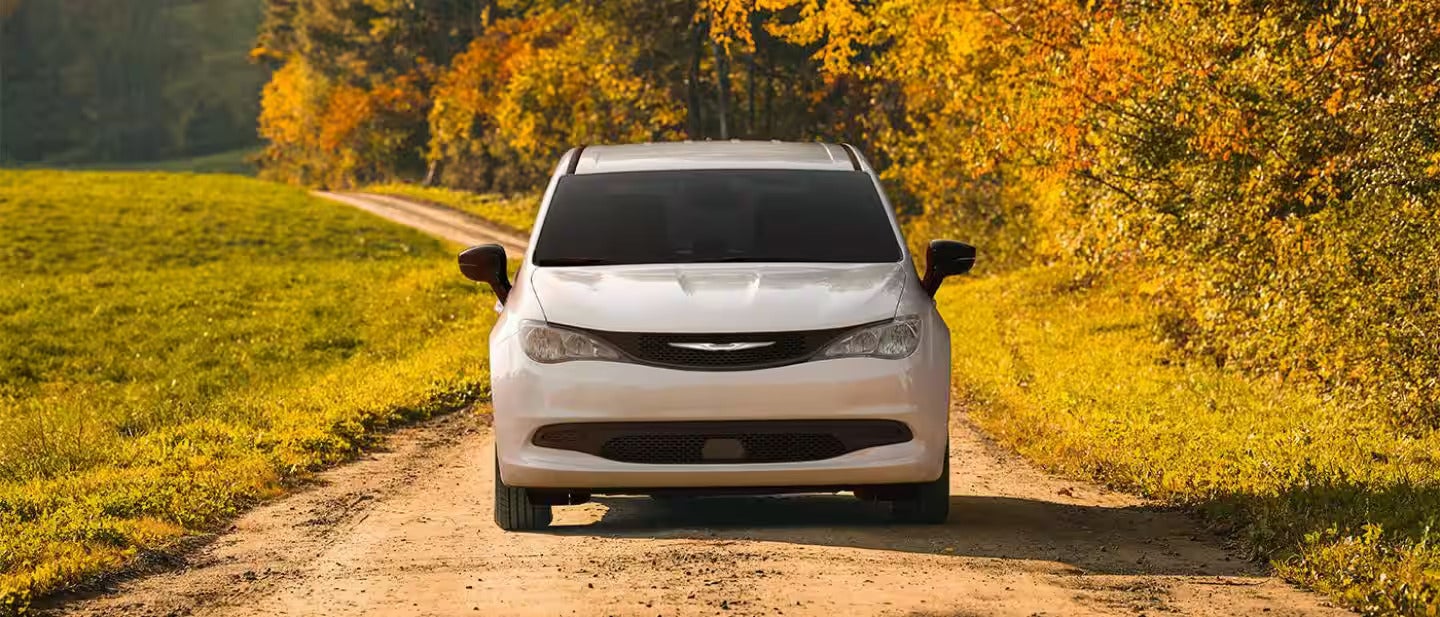 the front view of a 2025 chrysler voyager driving on a dirt path