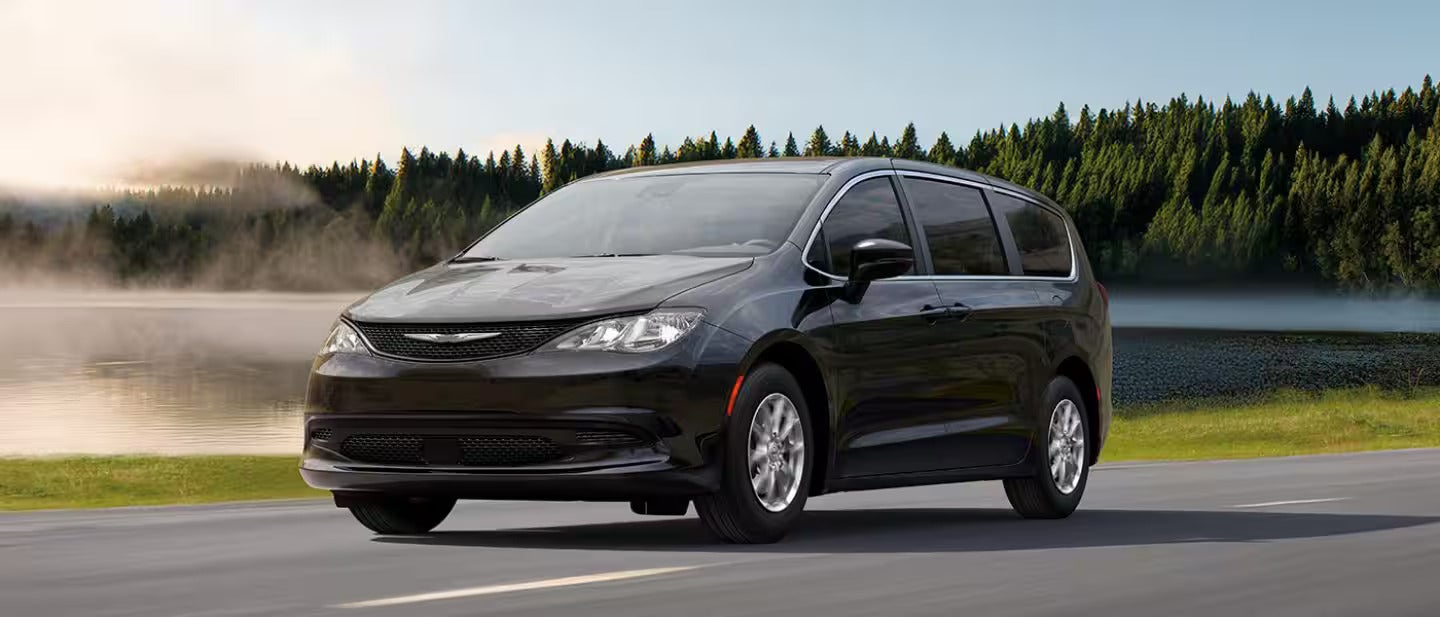a black chrysler voyager driving on the highway