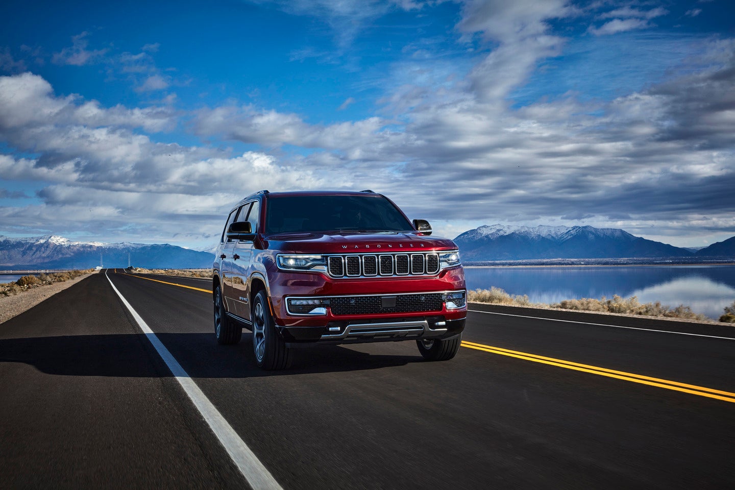 2025 jeep wagoneer hauling a silver bullet camper with desert terrain in the background