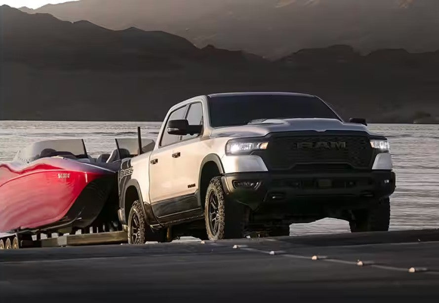 A gray truck pulling a boat out of the water.