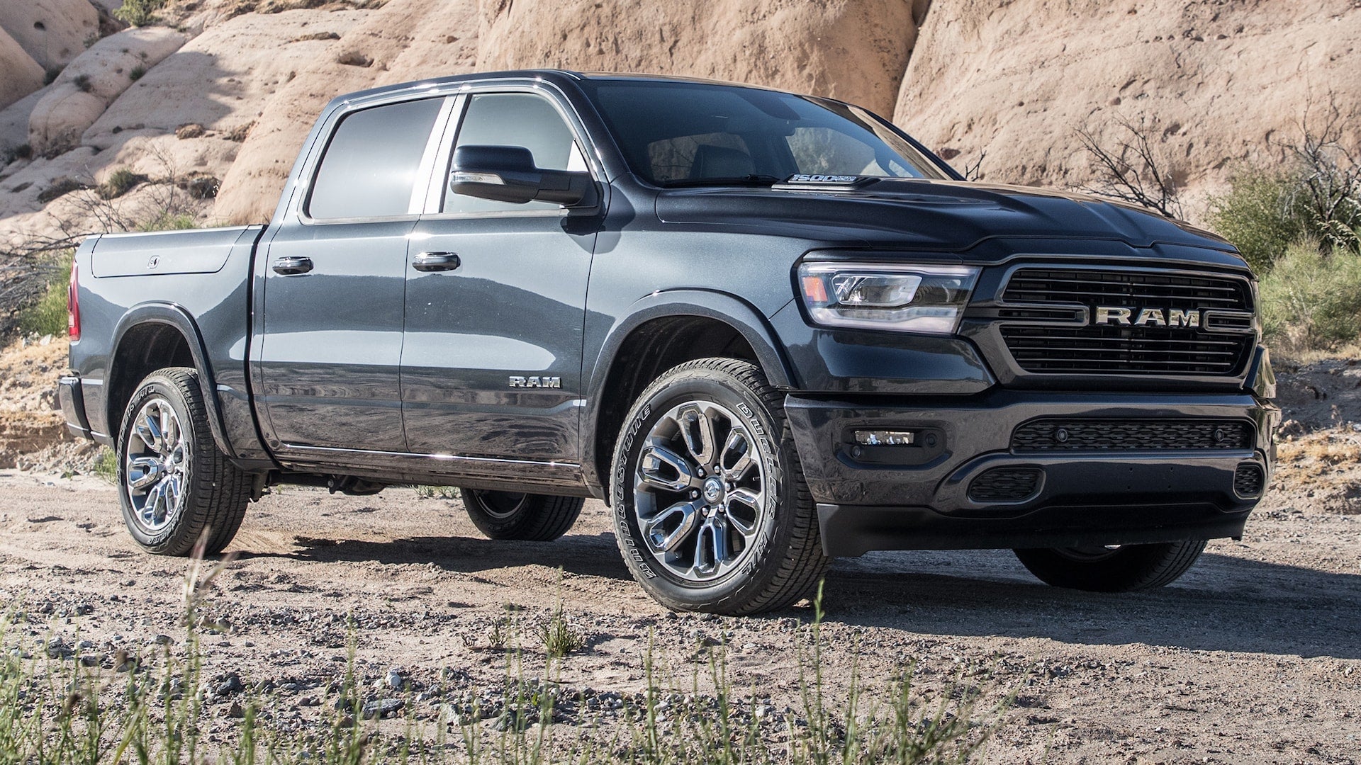A dark steel colored 2019 RAM sitting on a dusty trail.